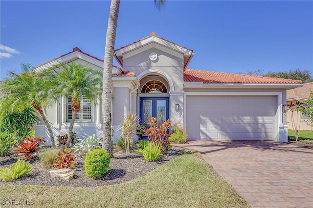 mediterranean / spanish-style home with french doors and a garage