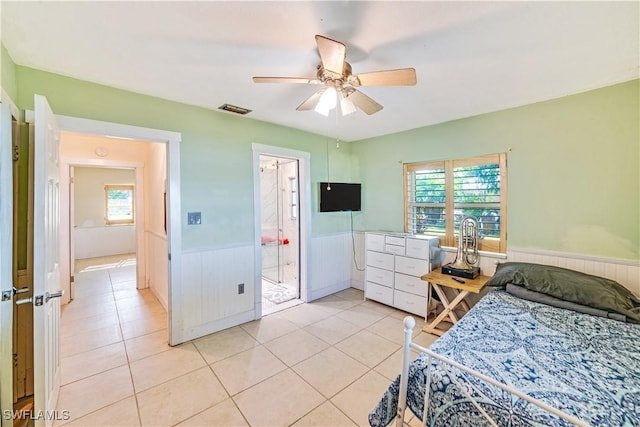 bedroom with ceiling fan, ensuite bathroom, and light tile patterned floors