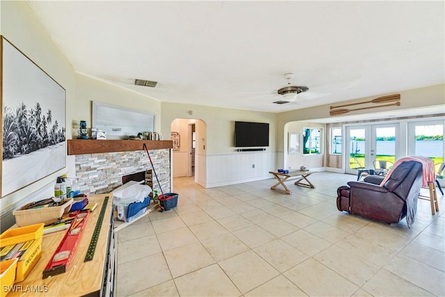 living room with light tile patterned floors, a fireplace, and french doors