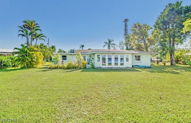 rear view of house featuring a yard