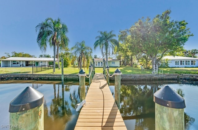 dock area with a water view and a lawn