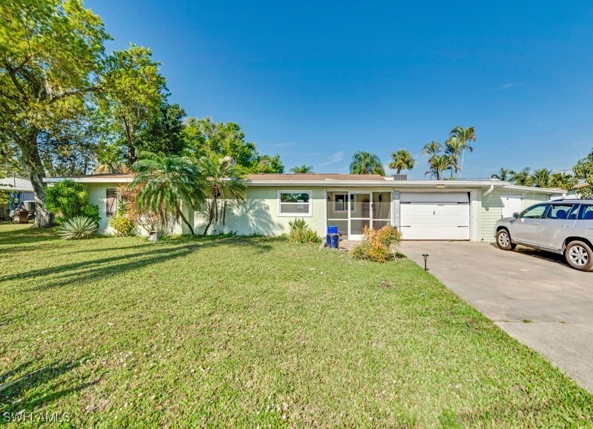 ranch-style house with a garage and a front lawn