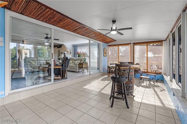 unfurnished sunroom with ceiling fan