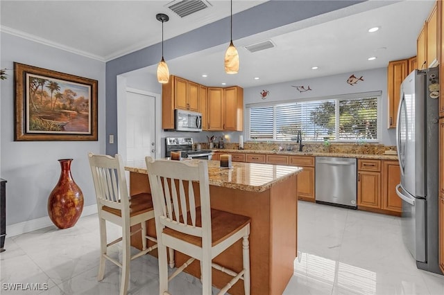 kitchen with stainless steel appliances, sink, a breakfast bar area, and light stone counters