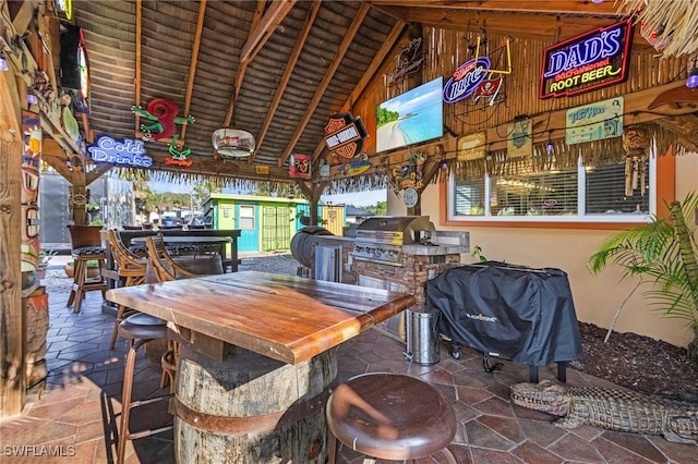 view of patio featuring beam ceiling and high vaulted ceiling