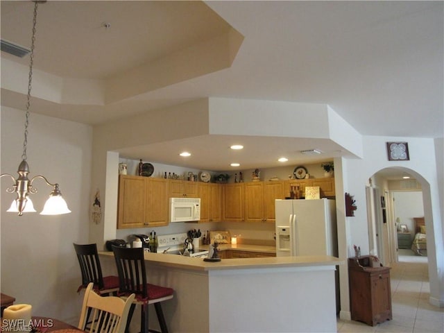 kitchen with white appliances, hanging light fixtures, a kitchen breakfast bar, light tile patterned flooring, and kitchen peninsula