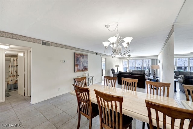 dining room with light tile patterned flooring and a notable chandelier