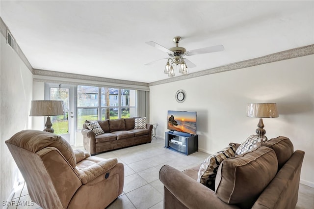 tiled living room featuring ceiling fan and ornamental molding