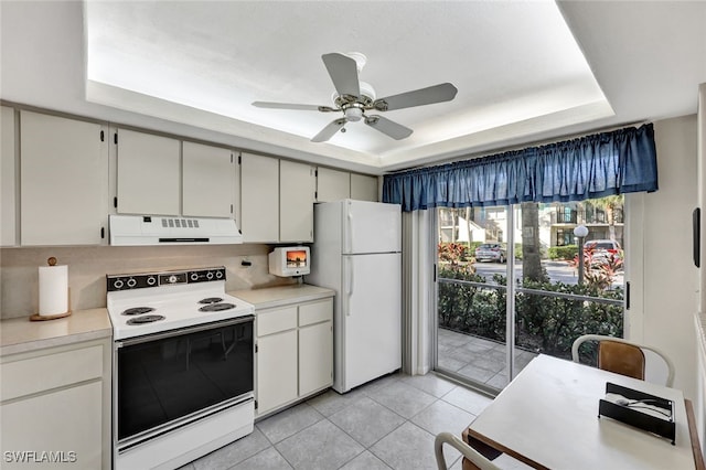 kitchen featuring range with electric stovetop, a raised ceiling, white cabinets, and white fridge