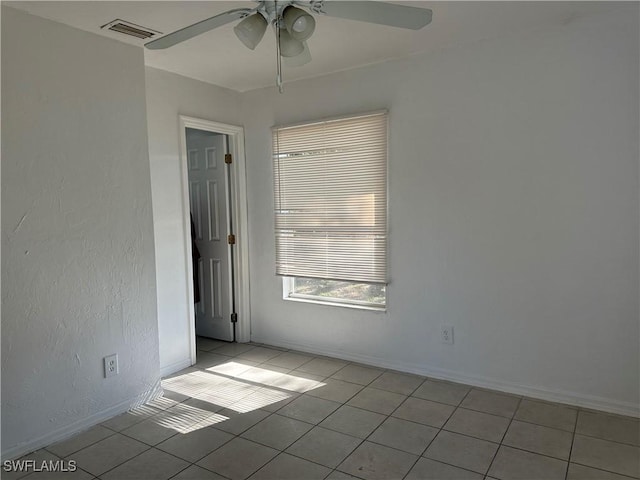 tiled spare room with ceiling fan