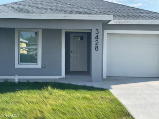 view of front of house with roof with shingles, concrete driveway, and an attached garage