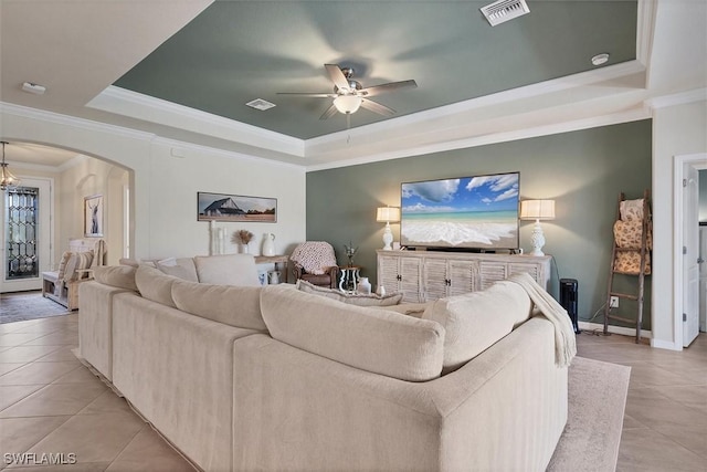 tiled living room featuring crown molding, ceiling fan, and a raised ceiling