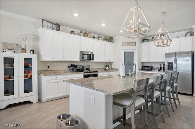 kitchen with appliances with stainless steel finishes, sink, white cabinets, a kitchen island with sink, and crown molding