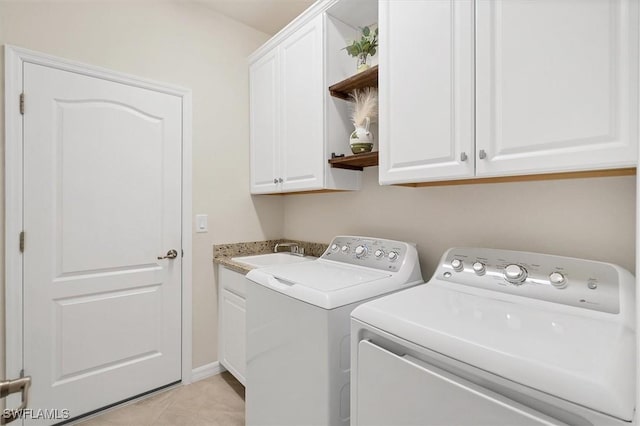 laundry area with sink, cabinets, washer and dryer, and light tile patterned flooring