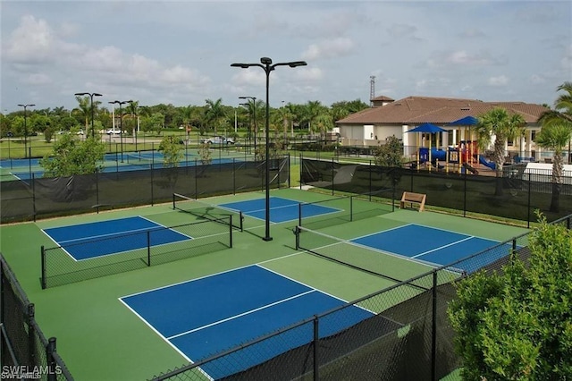 view of tennis court with a playground