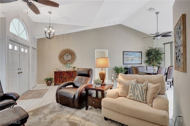 tiled living area featuring high vaulted ceiling, visible vents, and ceiling fan with notable chandelier