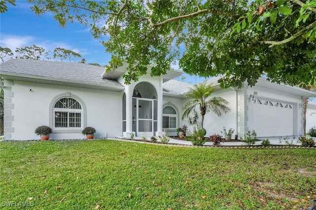 ranch-style house featuring a garage, a front yard, and stucco siding