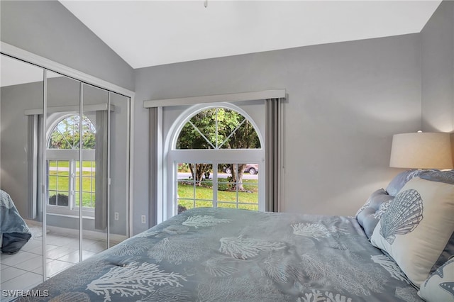 tiled bedroom with lofted ceiling, access to outside, and a closet