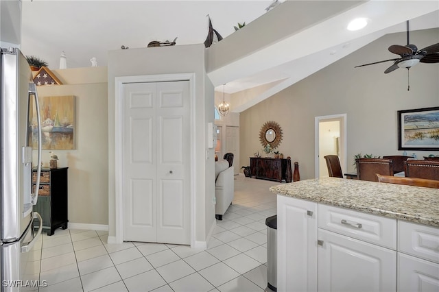 kitchen with open floor plan, light tile patterned floors, stainless steel refrigerator with ice dispenser, and white cabinetry