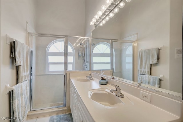 full bathroom featuring double vanity, a stall shower, and a sink