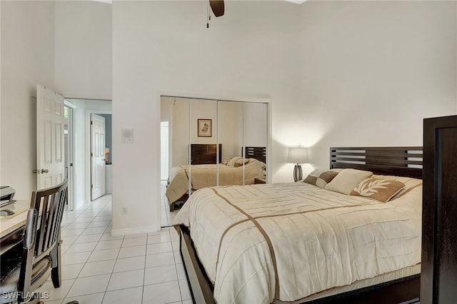 bedroom with a ceiling fan, baseboards, a high ceiling, and light tile patterned floors