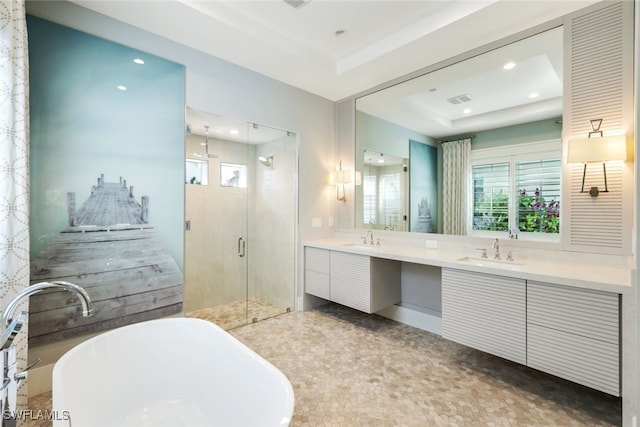 bathroom with independent shower and bath, vanity, and a raised ceiling