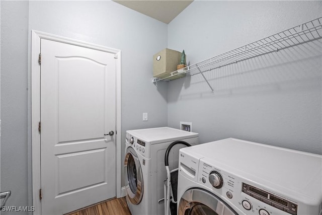 laundry room with wood-type flooring and washer and dryer