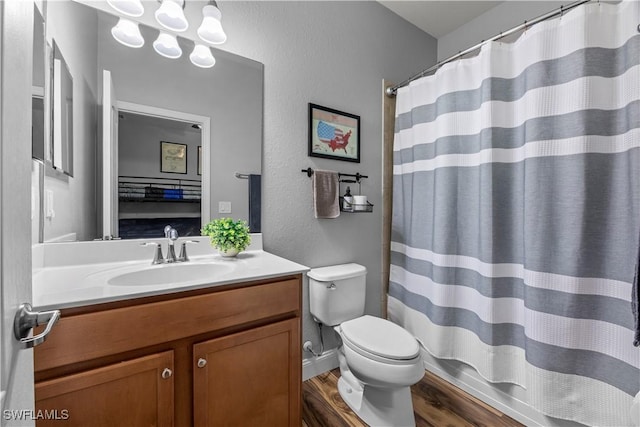 bathroom with wood-type flooring, a shower with shower curtain, vanity, and toilet