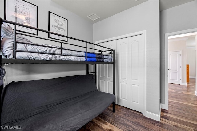 bedroom featuring dark hardwood / wood-style flooring and a closet