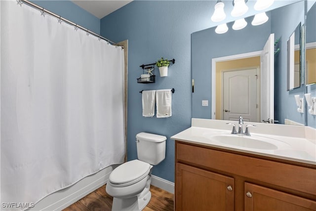 full bathroom featuring hardwood / wood-style flooring, vanity, shower / bath combo with shower curtain, and toilet