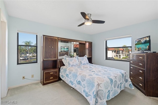 bedroom with light carpet and ceiling fan