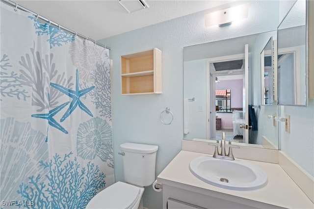 bathroom featuring vanity, curtained shower, and toilet