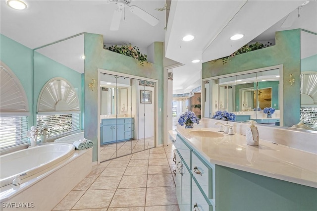 bathroom with vanity, tile patterned flooring, a relaxing tiled tub, and ceiling fan