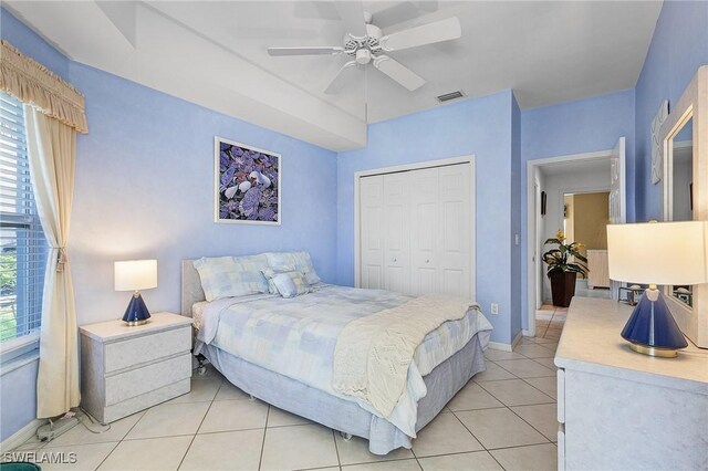 bedroom with light tile patterned floors, a closet, and ceiling fan