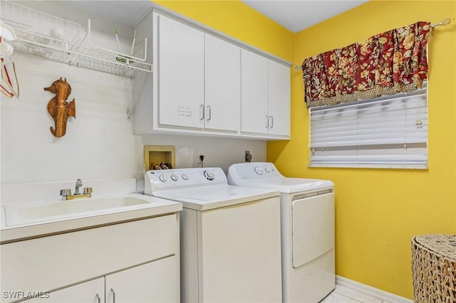 clothes washing area featuring cabinets, sink, and independent washer and dryer