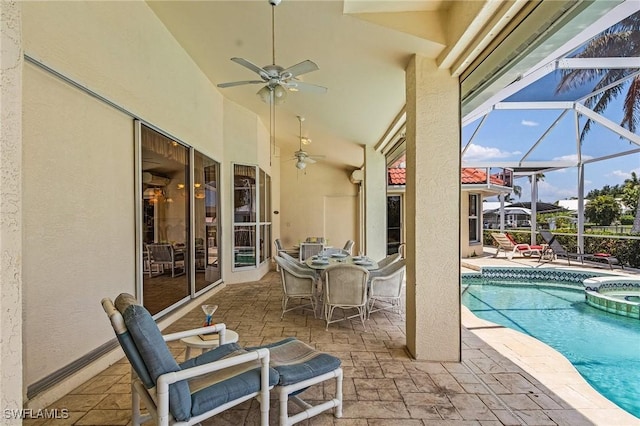 view of pool with a lanai, a patio, ceiling fan, and an in ground hot tub