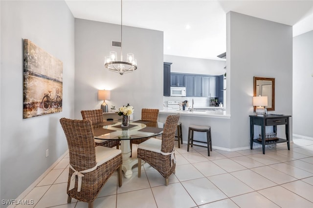 dining area featuring light tile patterned flooring, sink, and a chandelier