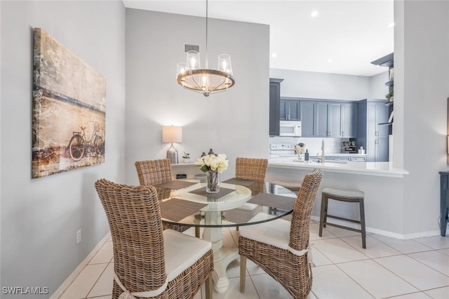 tiled dining space featuring sink and a notable chandelier