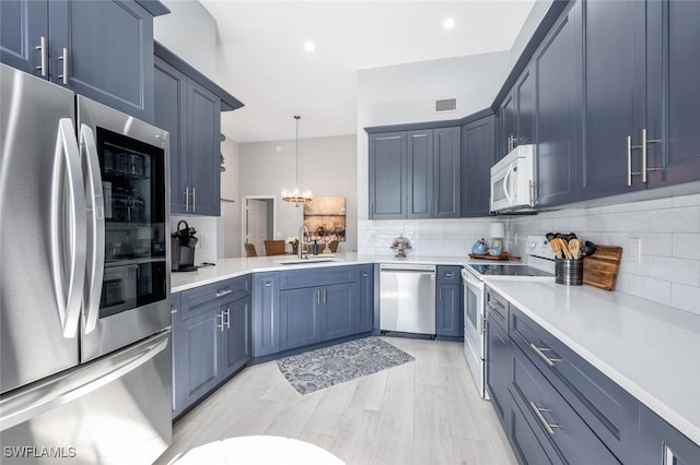 kitchen featuring pendant lighting, sink, blue cabinets, and appliances with stainless steel finishes