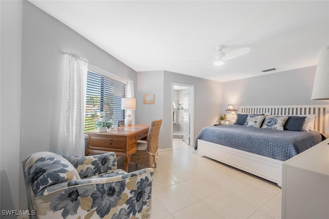 bedroom featuring connected bathroom, light tile patterned floors, and ceiling fan