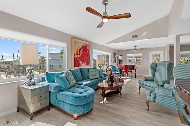 living room featuring vaulted ceiling, a healthy amount of sunlight, ceiling fan, and light hardwood / wood-style flooring