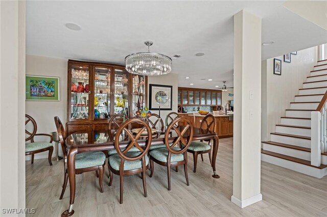 291 Flamingo St, Fort Myers Beach, FL 33931 - dining space featuring an inviting chandelier, light wood-style flooring, stairway, and recessed lighting