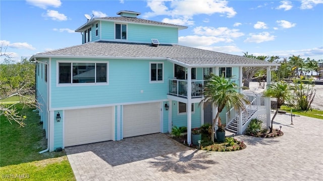 291 Flamingo St, Fort Myers Beach, FL 33931 - rear view of property with decorative driveway, an attached garage, stairway, covered porch, and a shingled roof