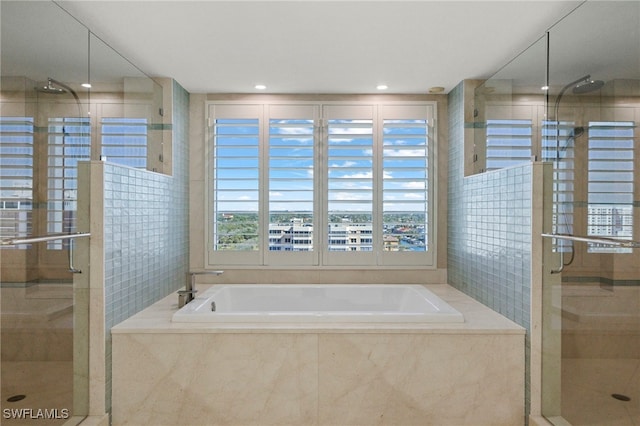 bathroom featuring shower with separate bathtub and tile walls