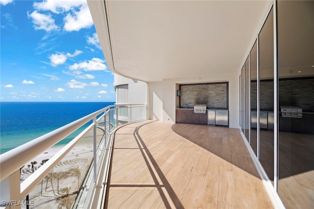 balcony with a water view and area for grilling