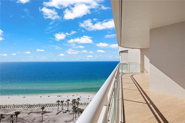 balcony featuring a view of the beach and a water view