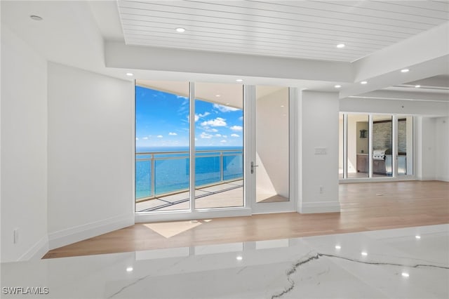 spare room featuring a water view and light wood-type flooring