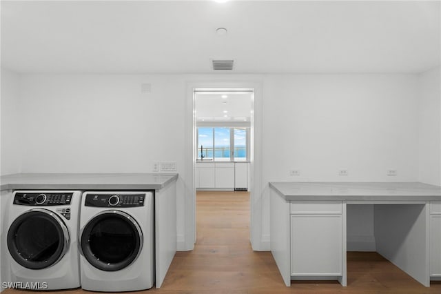 laundry area featuring washer and dryer and light wood-type flooring