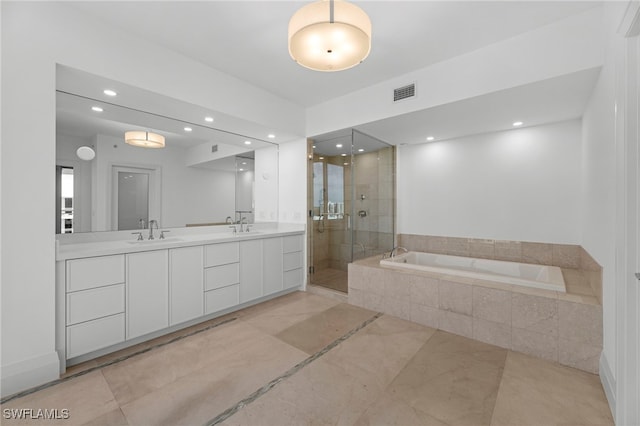 bathroom with vanity and shower with separate bathtub