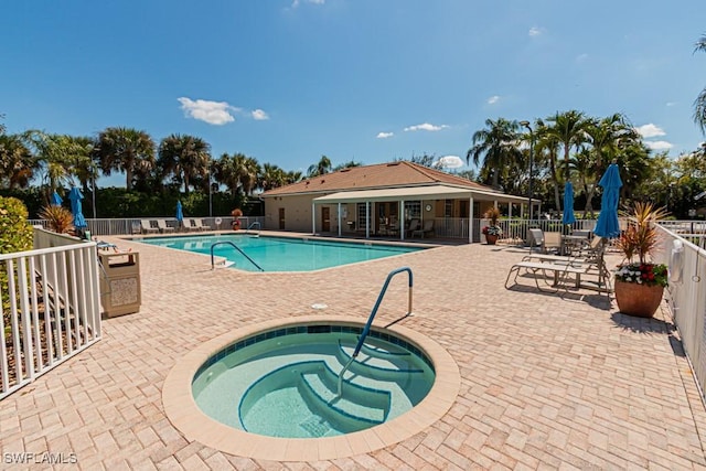 pool featuring a patio area, fence, and a community hot tub